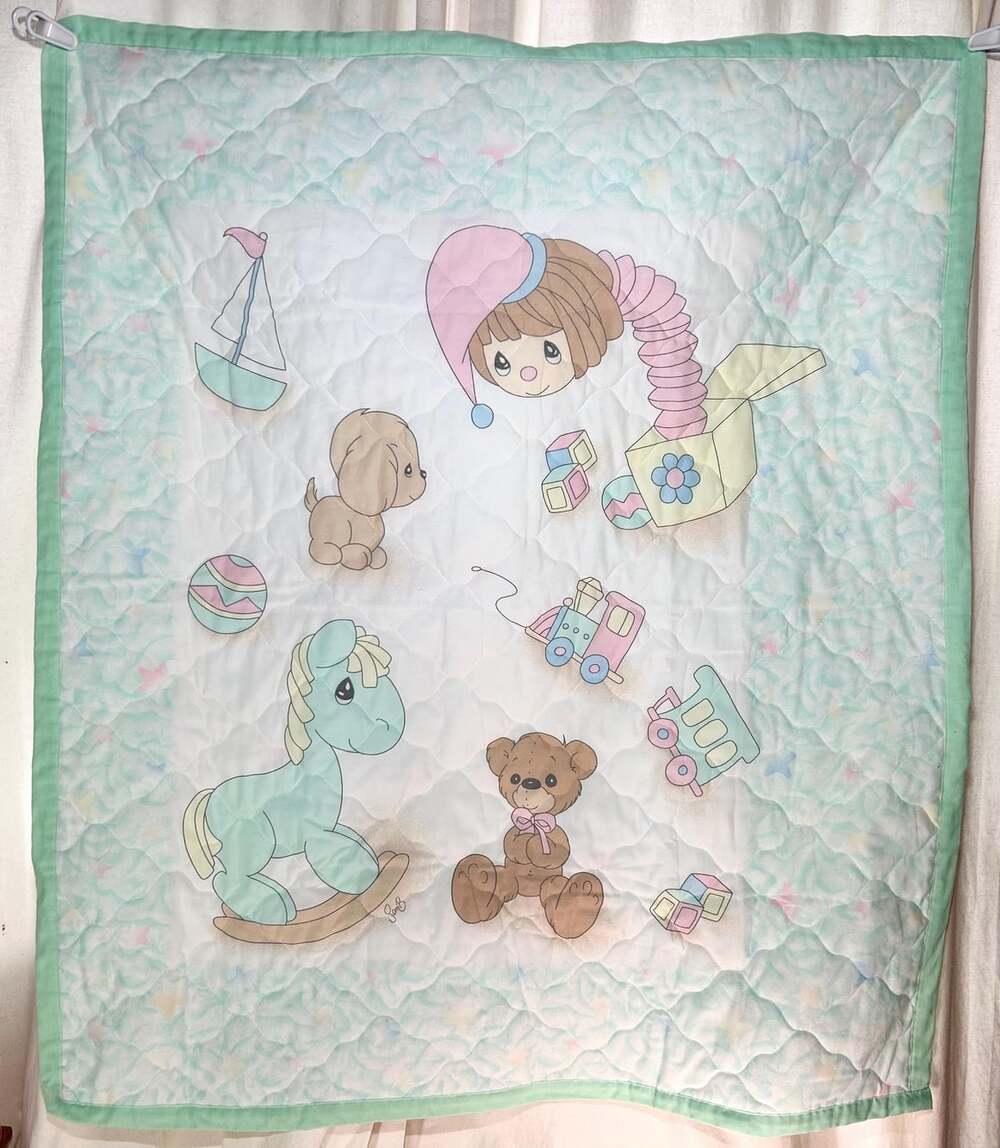 A beautifully hand made Precious Moments Baby Quilt in gorgeous pastel colors wi